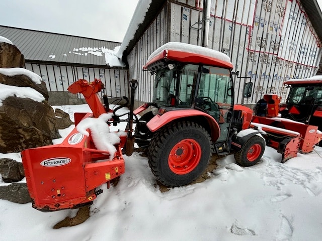 Snow blower tractor clearing a residential driveway